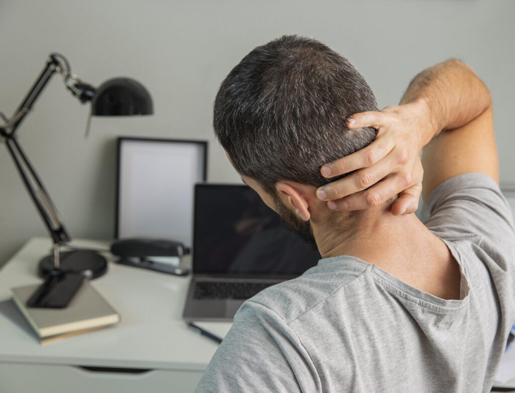 man holding his neck pain