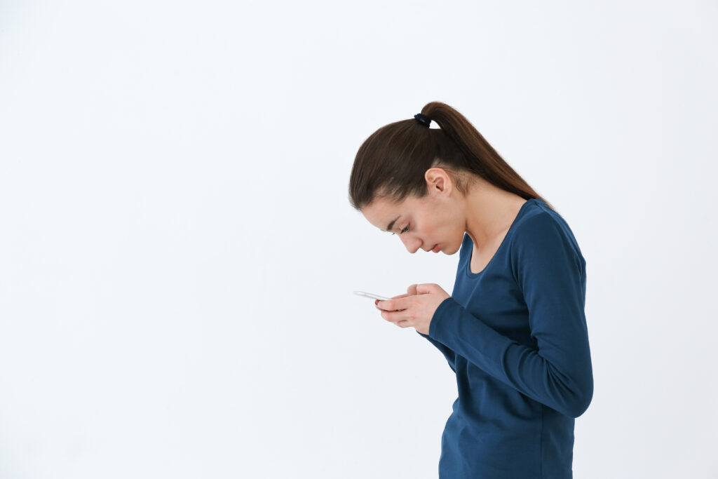 woman looking at her phone with poor posture
